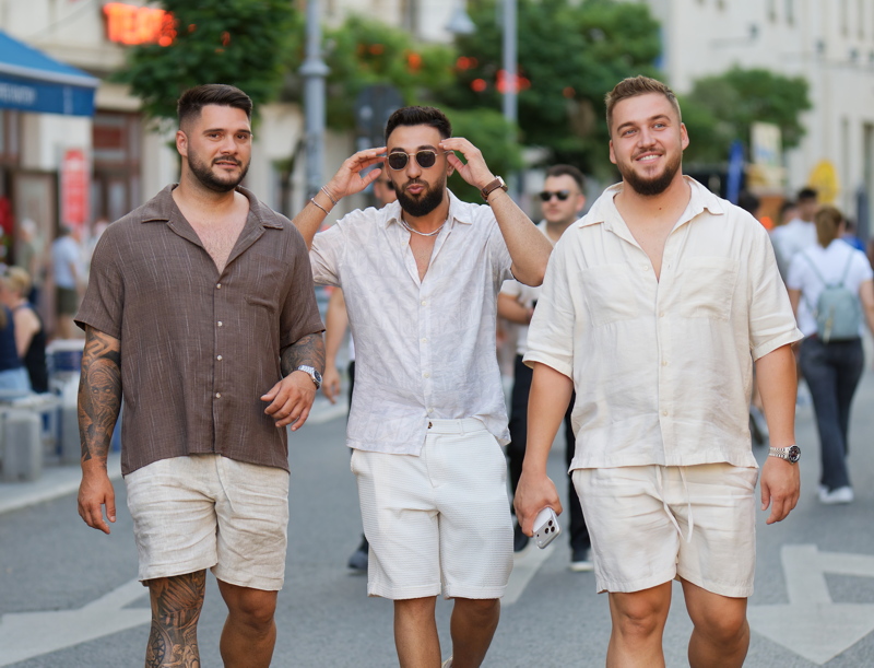 22 - Three men dressed in coordinated summer vacation linen outfits walking down a busy city street